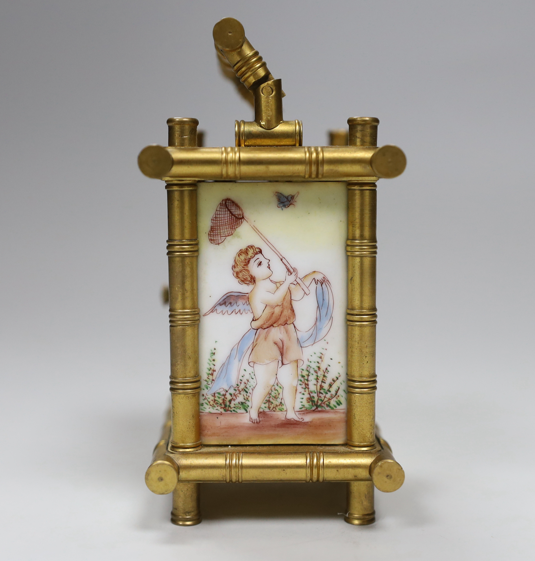 A French bamboo design carriage clock, with three porcelain putti decorated sides, by Elliot & Son, London, 9.5cm high